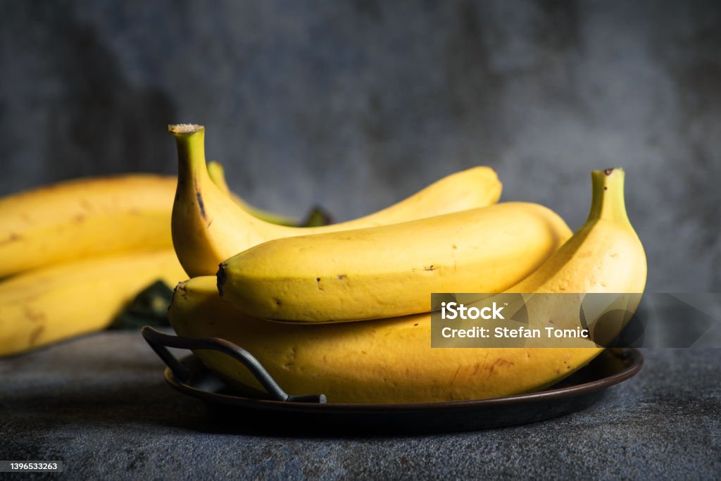 Fresh ripe bananas Fresh ripe bananas in a bowl on a black and gray background with copy space Banana Stock Photo