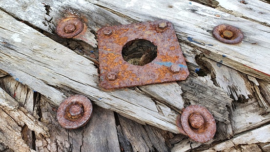 Close-up image of old rusty screw and bolt on steel surface with blurred background