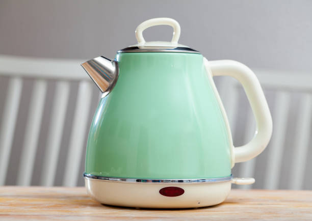 istock Turquoise electric tea kettle on wooden table 1396535465
