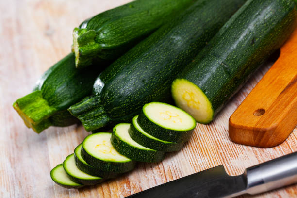 istock Whole and sliced fresh zucchini on wooden table 1396535550