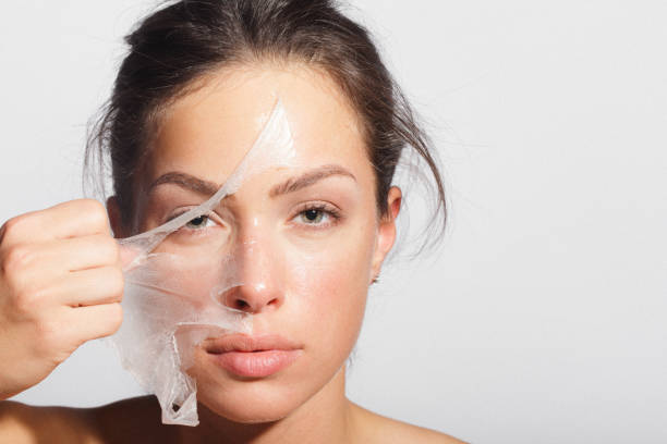 Beauty portrait of a young woman applying-removing face mask stock photo
