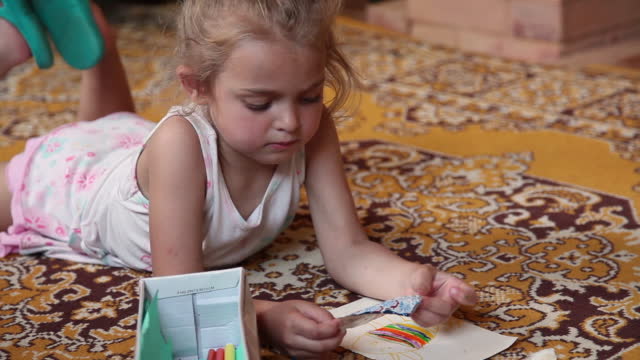 Little girl unfolding empty candy wrapper