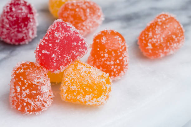 CBD gummy candy gumdrops close up on a white marble surface stock photo