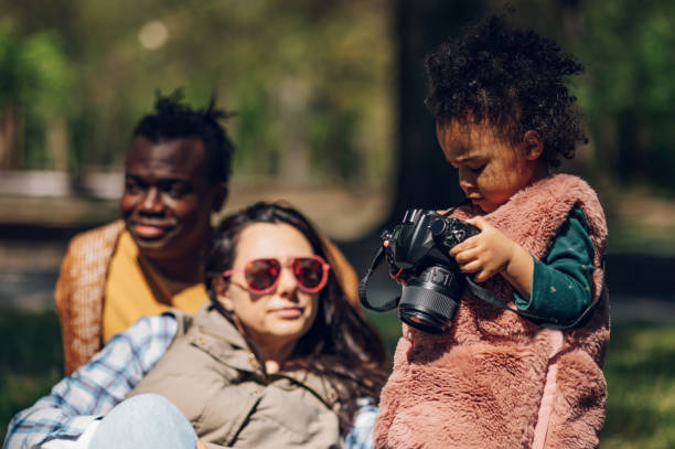 istock Beautiful multiracial family using a digital camera in the park. 1396538141
