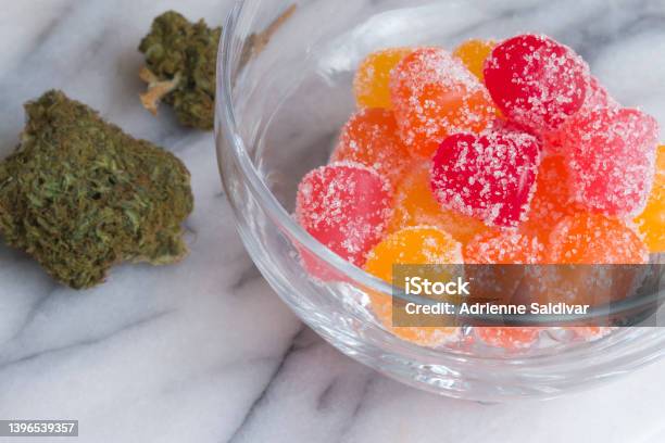 Cbd Gummy Candy Gumdrops And Buds On A White Marble Surface Stock Photo - Download Image Now