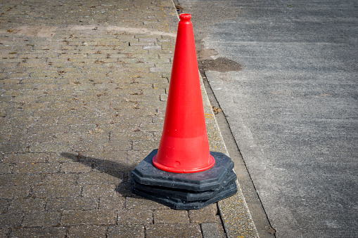 Stack of red road cones on pavement