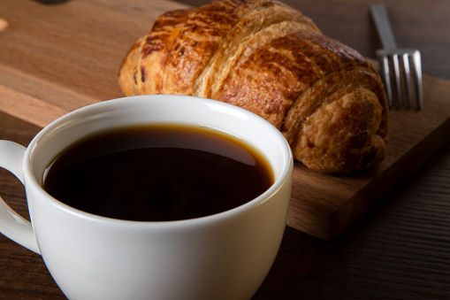Croissant with a cup of full coffee