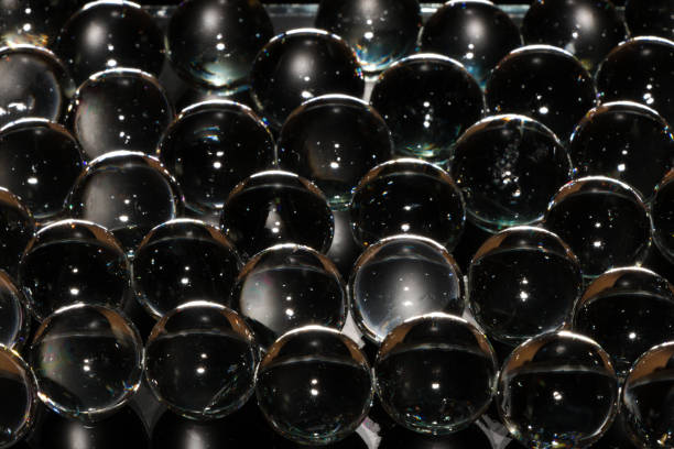bolas de vidrio 3d sobre un fondo negro cuentas transparentes - glass bead fotografías e imágenes de stock