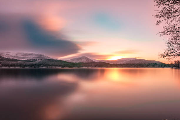 loch morlich, aviemore bei schönem sonnenuntergang sonnenaufgang während der ruhe - highlands region loch reflection mountain stock-fotos und bilder