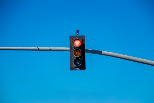 Photo of a traffic light against a blue sky.