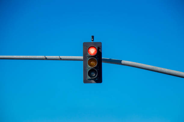 Traffic Light Against Blue Sky Photo of a traffic light against a blue sky. blue yellow lights stock pictures, royalty-free photos & images