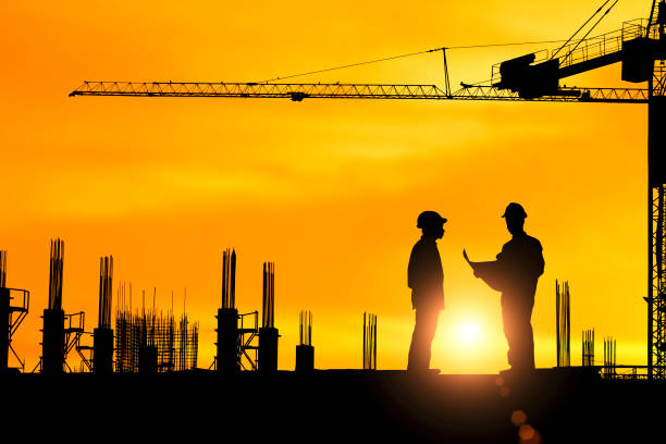 istock Silhouette of engineer explaining the construction worker to the building plan for the correct understanding. 1396560355