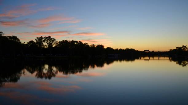 Calm and tranquil pink and golden dawn sunrise  on the Murray River near Mildura in outback Australia stock photo