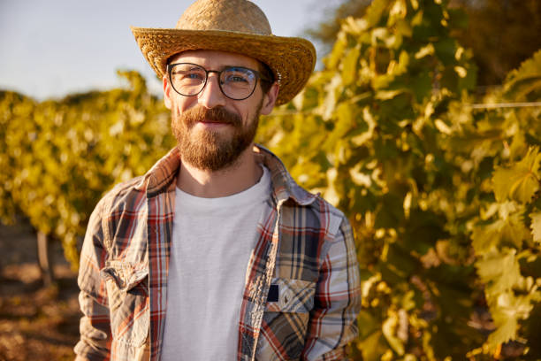 istock Smiling bearded farmer standing in vineyard 1396569802