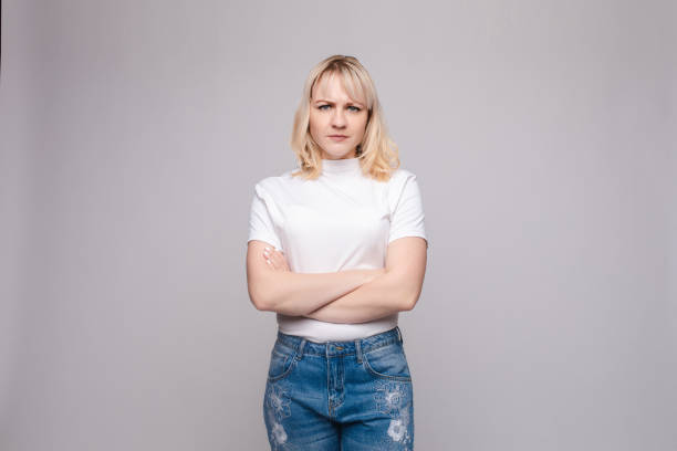 istock Angry or sad girl with folded arms. 1396570501
