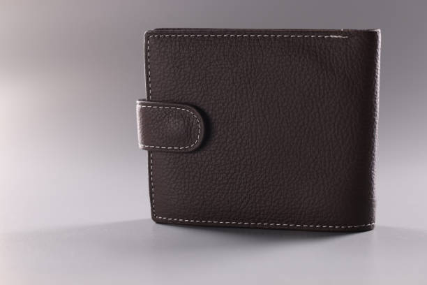 istock Brown leather wallet with button, full of banknotes and credit cards inside 1396574560
