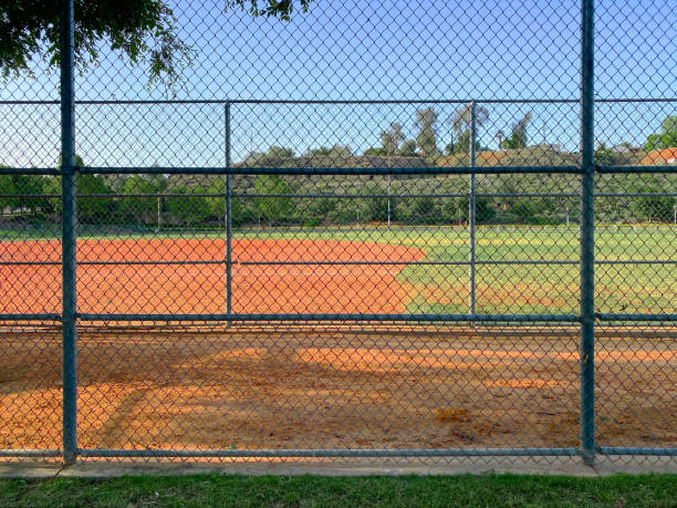 catena link recinzione campo da baseball dugout pratica sport parco giochi vuoto ballpark - baseballs baseball grass sky foto e immagini stock