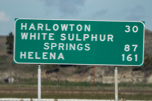 Street and highway information signs at intersection in Montana in northwestern United States of America (USA) - Harlowton, White Sulphur Springs, Helena