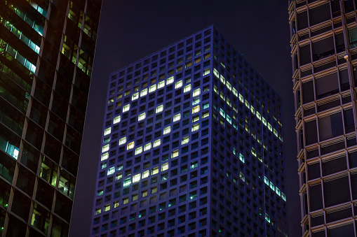 Happy face shape in lights in downtown district office business buildings at night, digital composite