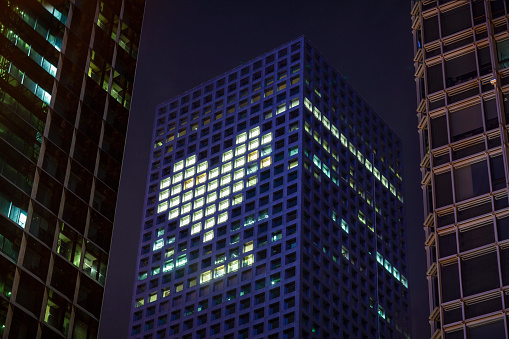 Heart shape in lights in downtown district office business buildings at night, digital composite