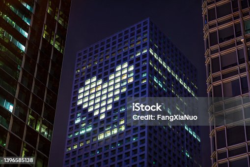 istock Heart shape in lights in downtown district office business buildings at night 1396585138
