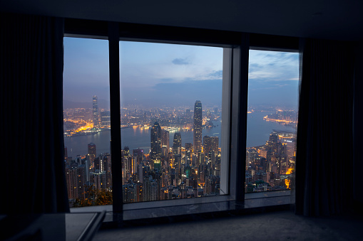 View of Hong Kong, China from within high rise apartment hotel room at dusk