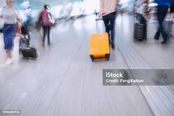 Passenger In A Hurry To Get To Flight With Rolling Luggage In Airport Terminal Stock Photo - Download Image Now