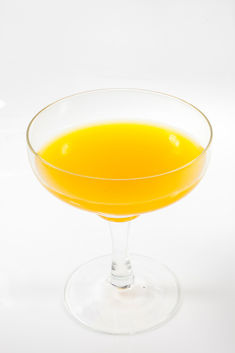 Orange juice in a glass on a white background.