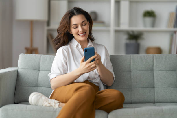 istock woman is using a phone sitting on a sofa 1396588972