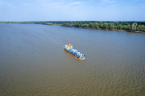 transportation of goods on river water. A barge is floating on the river. Transportation of goods.