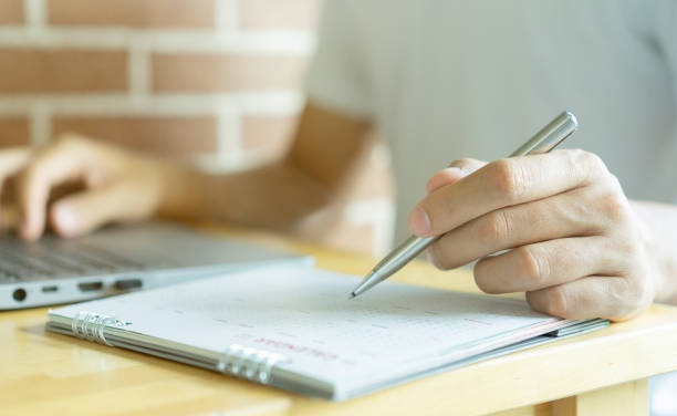 istock close up on employee man hand using pen to writing schedule on calendar to make appointment meeting or manage timetable each day at house for work from home concept 1396590872