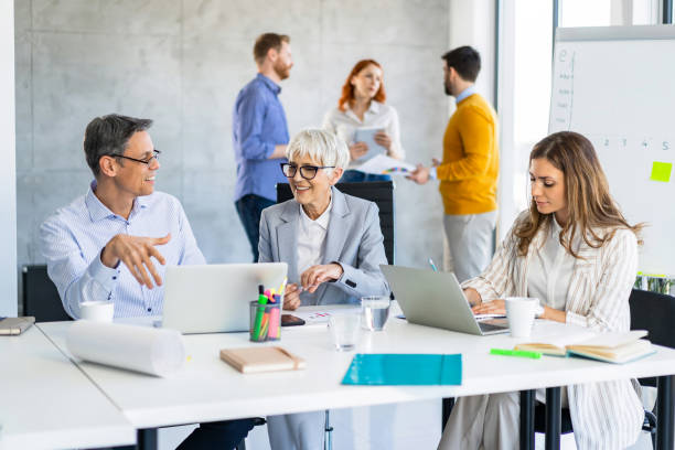 istock Happy mixed age range business people working together in the office 1396594210