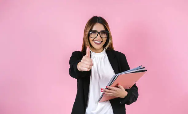 Photo of young hispanic business woman smiling at camera on pink background in Mexico Latin America