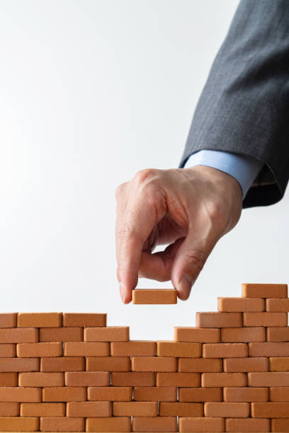 istock Businessman putting toy brick onto a wall 1396594509