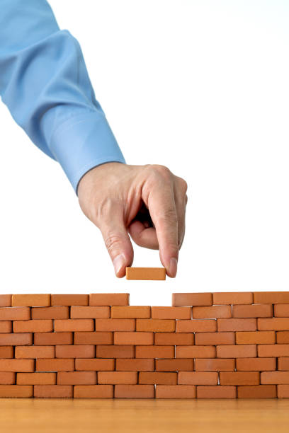 istock Businessman putting toy brick onto a wall 1396594525