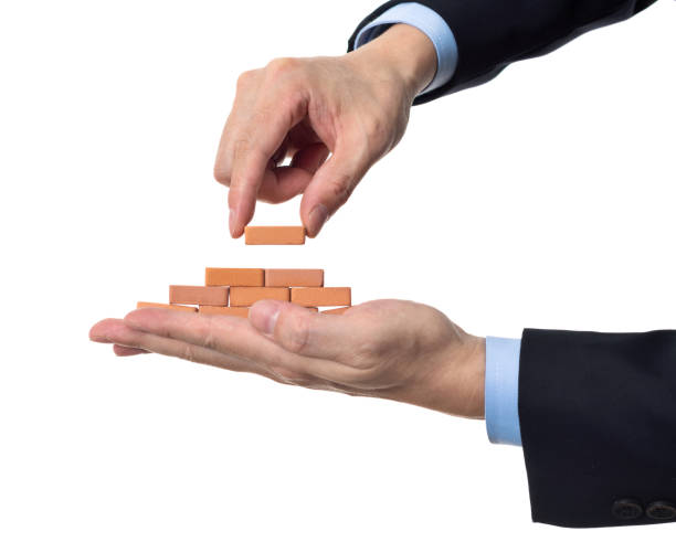 istock Businessman using toy brick build pyramid on hand 1396594548