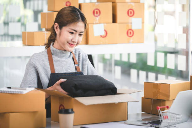 Portrait of a Startup, Small Business, SME Owner, Female Entrepreneur Packing in boxes, working on parcel boxes. Receipts and online order checks to prepare the boxes. Sell retrato de una startup, pequeña empresa, propietaria de pymes, empresaria empacando en cajas, trabajando en cajas de paquetes. recibos y cheques de pedidos en línea para preparar las cajas. vender