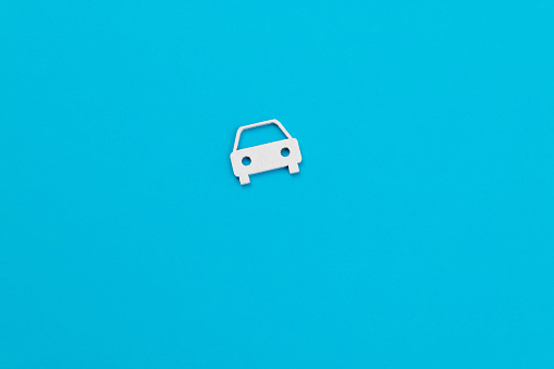 Small cardboard car on blue background.
