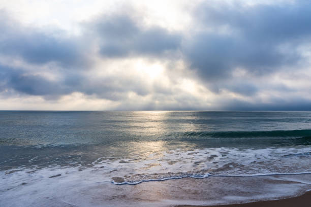 nascer do sol sobre o oceano atlântico na flórida. água calma, oceano de chumbo, nuvens exuberantes. visão reconfortante, relaxamento - city of sunrise fotos - fotografias e filmes do acervo