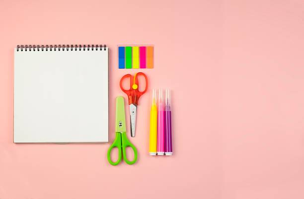 istock Blank notebook with office supplies on a light pink background. 1396598864