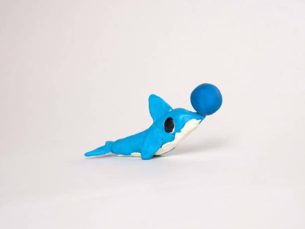 istock Plasticine craft blue dolphin with a ball on its nose. Sculpting for children, development of motor skills 1396600238
