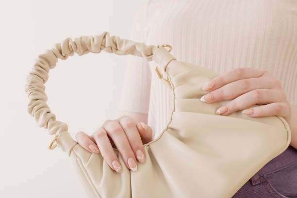 istock woman with handbag close up on white background 1396601236