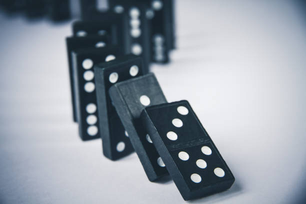 istock Black dominoes chain on white table background 1396605502