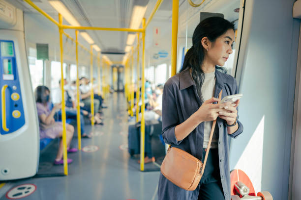 istock Asian working on smartphone in electric train. 1396606107