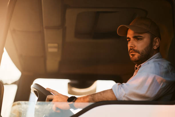 istock Young truck driver looking at side view mirror while driving in reverse. 1396606423