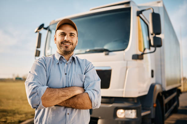 happy truck driver with crossed arms looking at camera. - chauffeur beroep stockfoto's en -beelden