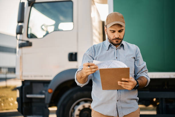 Truck driver going through paperwork before the ride. stock photo