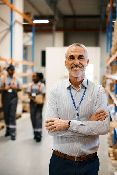 retrato de confidente gerente maduro del almacén de distribución mirando a la cámara. - manager foreman warehouse arms crossed fotografías e imágenes de stock