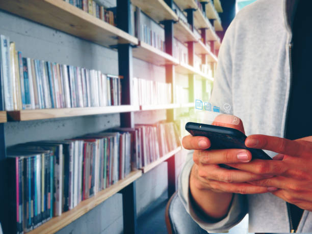 istock the student using mobile phone searching new media while making report in library 1396608786