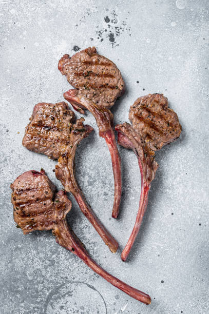 istock Grilled lamb mutton meat chops steaks. Gray background. Top view 1396612169